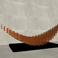 Wing Shaped Sculpture With Golden Orange Strips On Silver Base And Gray Wall