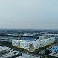 Aerial Planning of Industrial Zone With White Multi Story Buildings Blue Roofs And Greenery