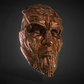 Copper Colored Intricate Carved Mask With Detailed Facial Features And Textured Surface