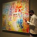 Vibrant Abstract Large Oil Painting With Dripping Paint And Artist Pointing On Gallery Wall