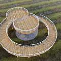 Elevated Spiral Walkway With White Railings And Wooden Supports In Open Grassland