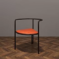 Modern Dining Chair With Black Frame Orange Padded Seat And Armrests On Wooden Herringbone Floor