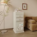 White Decorative Cabinet With Drawers And Photos Next To Sofa And Floor Lamp