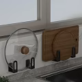 Transparent Pot Lid And Wooden Cutting Board Hanging On Black Hooks For Kitchen Wall