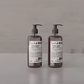 Two LA FABRIQUE Liquid Hand Soap Bottles On Grey Surface With Clean Design