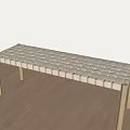 Light Colored Bench With Woven Surface And Wooden Legs On Wooden Floor Indoor