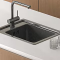 Stainless Steel Kitchen Sink With Modern Faucet On White Countertop And Wooden Cabinets
