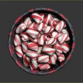 Red and white striped candy arranged in red and black woven basket