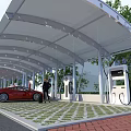 Electric Vehicle Charging Station Canopy With Charging Ports Parked Red Car And Green Grid Pavement
