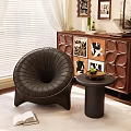 Dark Brown Leather Single Sofa With Curved Design Small Round Side Table And Green Plant