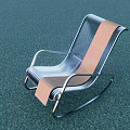 Modern Rocking Leisure Chair With Metal Frame Brown Silver Stripes On Green Surface