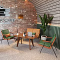 K Cafe Interior Featuring Brick Wall Wooden Panel Green Chairs Brown Bench And Large Plant