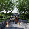 Garden Ornaments Featuring Stone Path Trees Greenery And Lantern Lights With People Walking