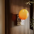 Orange Spherical Wall Lamp Mounted On Wooden Wall With Decorative Base And Green Leaves