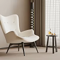Plush White Accent Chair With Black Legs And Small Round Side Table In Modern Room