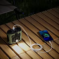Outdoor Wooden Table Setup With Smartphone Charging And Portable Digital Speaker