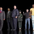Group of Diverse People Standing Against Black Background With Varied Clothing Styles