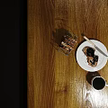 Toast With Jam On White Plate And Black Coffee Alongside Metal Toaster On Wooden Table