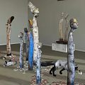 Indoor Sculpture Exhibition With Humanoid Animal Figures Pebbles And Wooden Ceiling
