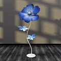 Floral Art Installation Featuring Blue Flower Metal Stem Decorative Leaves Shadow Effect On Wooden Floor