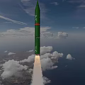 Green Missile Flying With Rocket Exhaust Over Ocean And Land Under Cloudy Sky