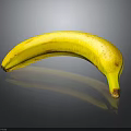 Ripe Yellow Banana With Brown Spots On Shiny Black Background