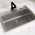 Black Modern Kitchen Faucet with Stainless Steel Sink on White Countertop
