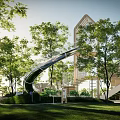 Outdoor Children's Play Area With Slide Climbing Structure And Green Trees Grass