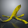 Yellow Banana Peel Shaped Sculpture With Curved Textured Design On Gray Reflective Background