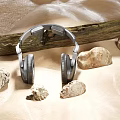 Silver Headphones On Light Colored Background With Wooden Log And Stones