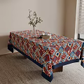 Colorful Geometric Pattern Tablecloth On Table With Vase Green Plant Book Window Blinds And Carpet