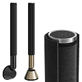 Black Headphones And Cylindrical Speaker With Silver Edge And Small Dots On Top