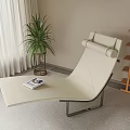 Beige Modern Lounge Chair With Green Plant Magazine And Wooden Bookshelf In Indoor Space