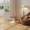 Modern Round Top Side Table With White Base Near Bean Bag Chair And Floor Lamp