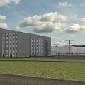 Modern Multistory Industrial Factory Building With Gray Exterior Large Windows Green Lawn And Clear Sky