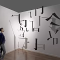 Cultural Art Gallery With Abstract Wall Installations And Visitor Viewing Artworks In Modern Interior Space