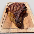 Perfectly Grilled Juicy Steak On Wooden Cutting Board With Charred Edges