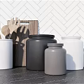 Wooden Kitchen Utensils And Storage Jars On Dark Countertop With Herringbone Tile Wall