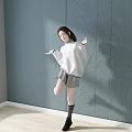 Woman Dancing in White Sweater Gray Skirt Striped Socks Black Shoes Against Blue Wall