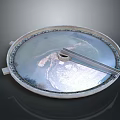 Circular Metal Lid With Shiny Surface Central Handle And Rim Design