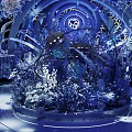 Luxurious Restaurant Interior With Blue Lighting Crystal Decor Circular Chandeliers Elephant Sculptures And Tiered Stage