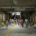 Busy Subway Station Interior With Seats Advertising Boards Escalator And People Walking