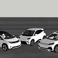 Three White Electric Vehicles Parked On Open Ground With Scenic Background