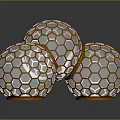 Three Honeycomb Patterned Spheres With Golden Frames And Transparent Interior On Reflective Surface
