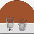 Transparent Glass Cups With Ribbed Design Against Orange Semicircle Background