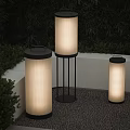 Three Cylindrical Outdoor Floor Lamps With Black Base Translucent Striped Shade In Garden