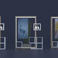Display Shelves with Framed Decorative Artworks Green Plants and Geometric White Shelves on Dark Background