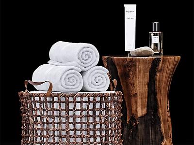 White Rolled Towels in Wicker Basket with Wooden Stump Table and Skincare Products 3d model