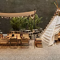 Canvas Tepee Tent With String Lights Tables Chairs And Green Plants On Gravel Ground