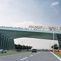 Modern Arched Entrance Gate of Ningbo Hangzhou Bay New Area with Road Vehicles and Streetlights